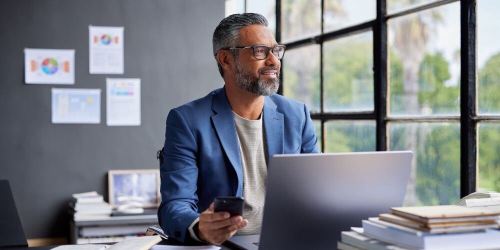 A business leader working on a laptop, researching strategies on how to become a cybersecurity champion for your organization.