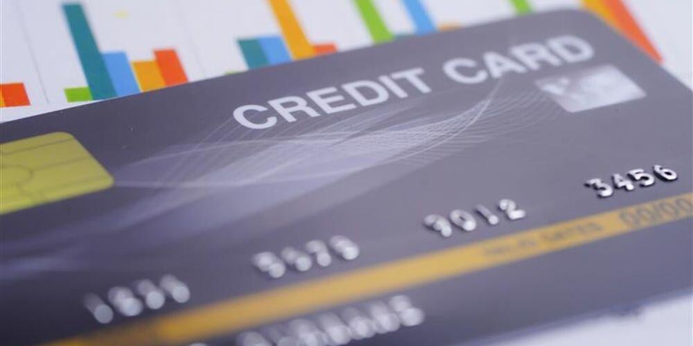 A credit card placed on financial charts, representing how an MSSP helps with PCI compliance and secure payment processing