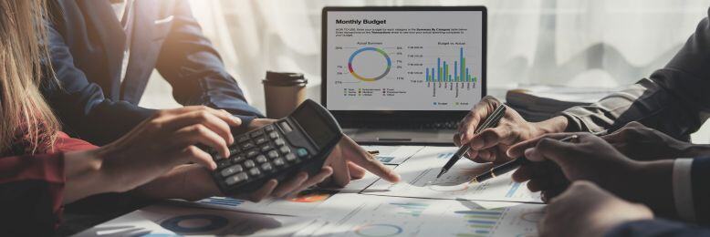 Business team analyzing budget constraints due to cheap IT solutions, showing charts and calculators