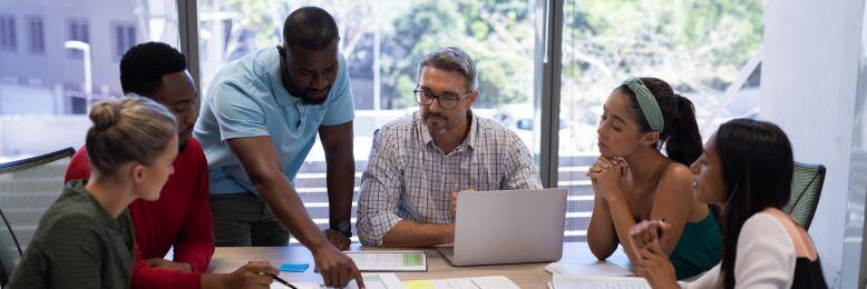 Diverse team collaborating at a meeting, highlighting strategies to select the right compliance MSP