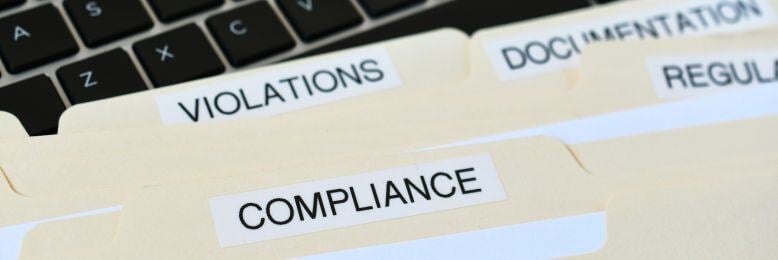 File folders labeled compliance, violations, and documentation for ITS custom IT compliance policy