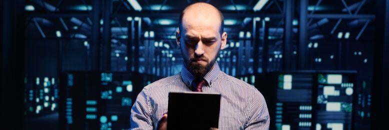 IT manager examining incident response protocols on a tablet in a data center