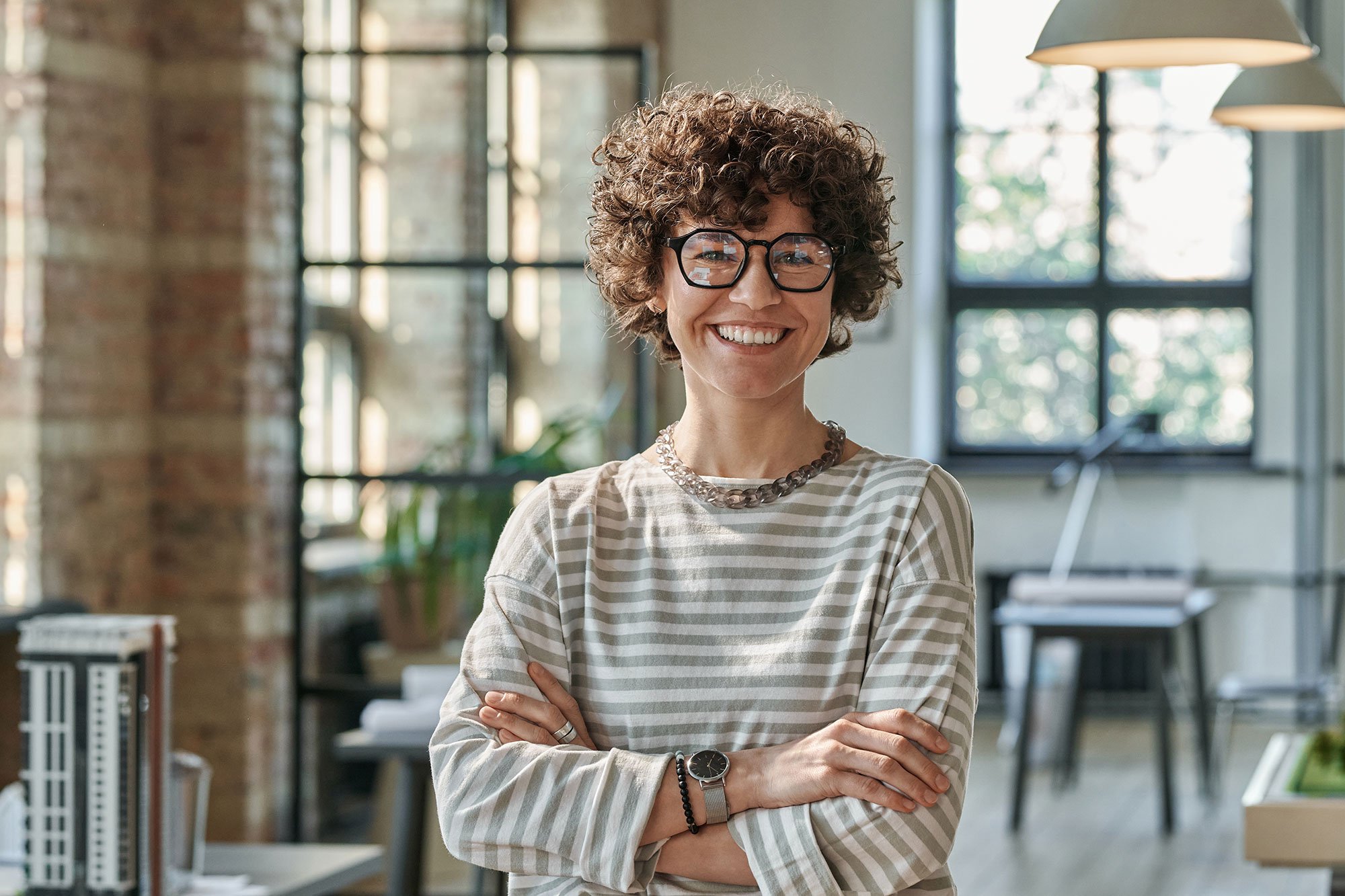 archi_bofu-(Portrait-of-young-successful-architect-in-eyeglasses-standing-with-arms-crossed-at-office-and-smiling-at-camera)