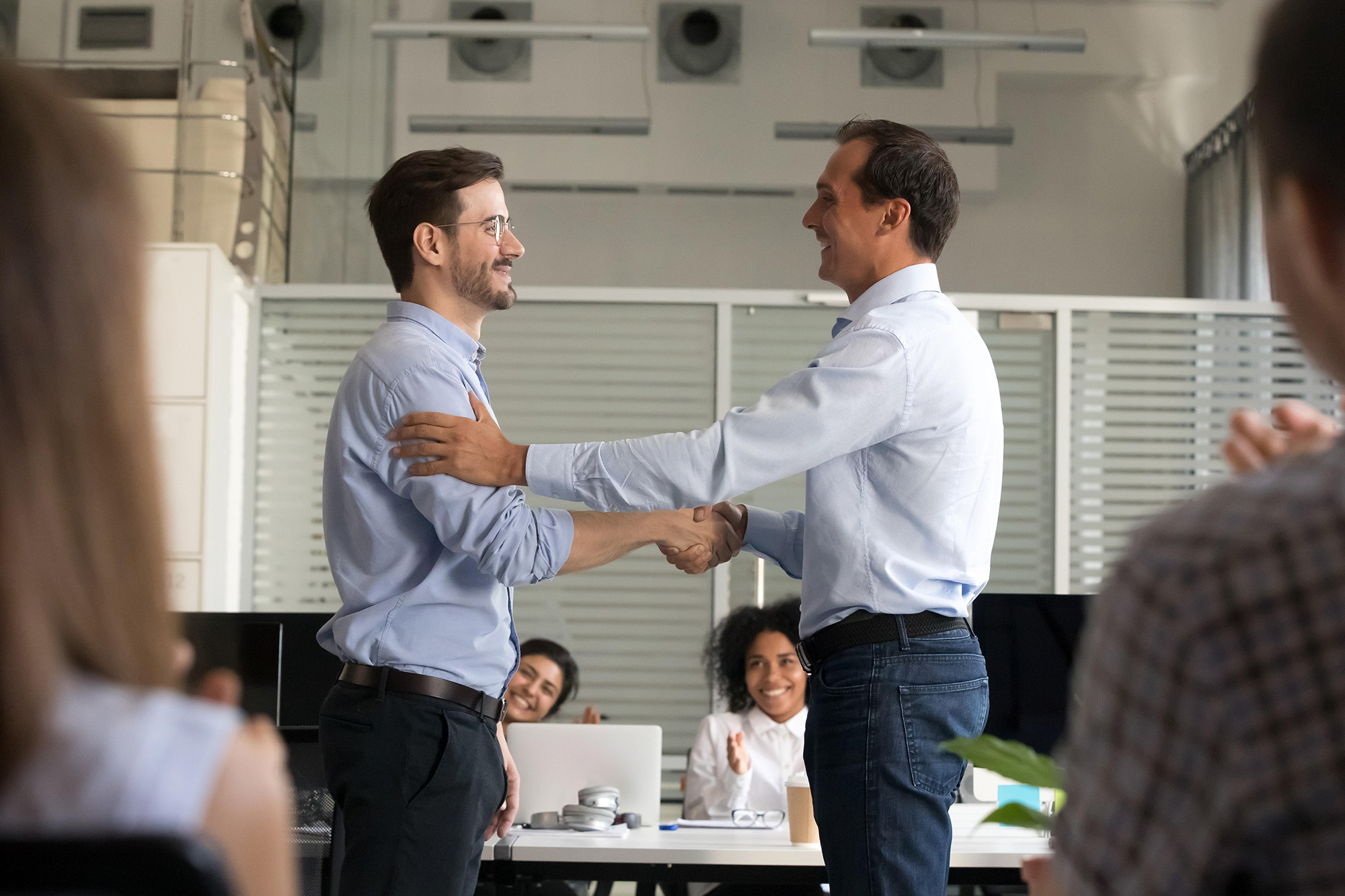 Boss or ceo shake hand of male employee congratulating with job promotion at work