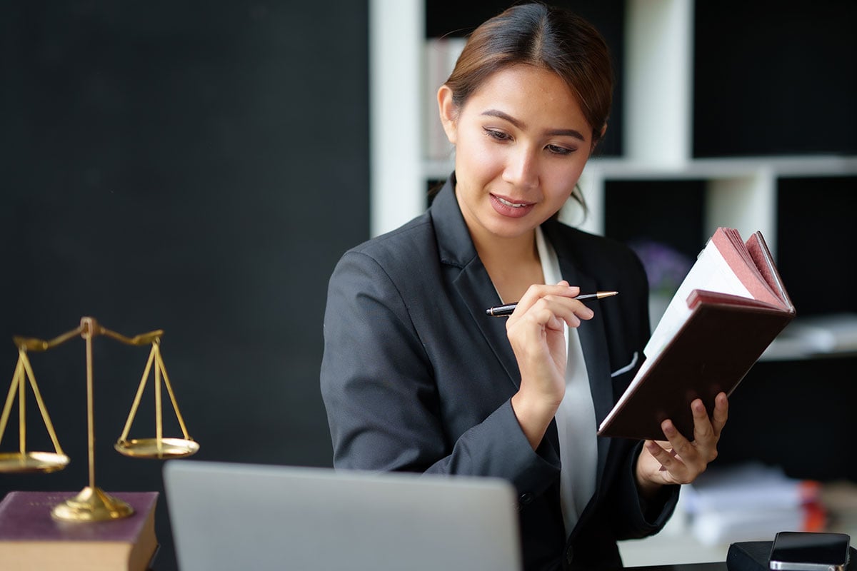 Asian lawyer woman is reviewing various legal clauses to support the case file