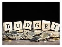 the word budget spelled out using blocks on top of coins