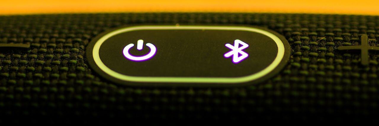 a bluetooth button beside the power button on a portable speaker